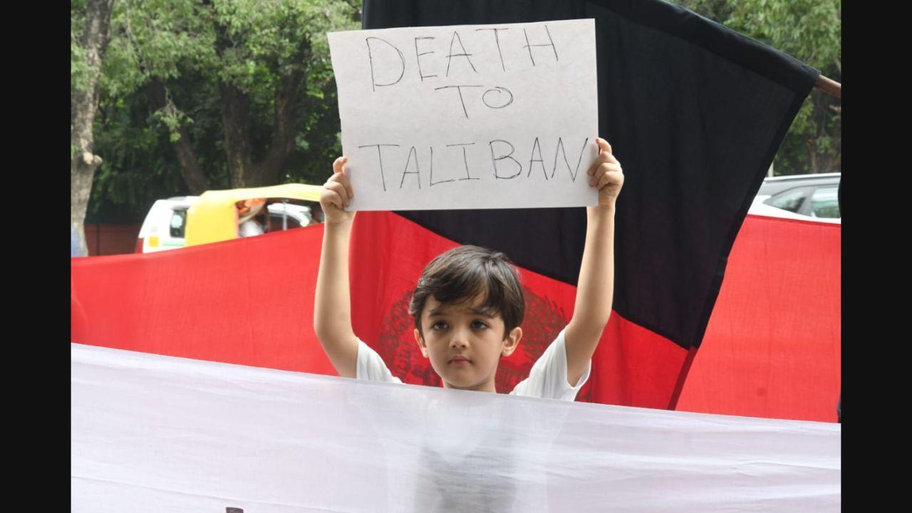 A kid holds a placard during a protest against Taliban's takeover of Afghanistan, in Delhi. Pic/Pallav Paliwal